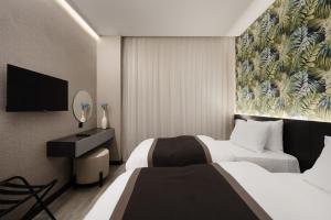 代胡克DDK Hotel Duhok的酒店客房设有两张床和一台平面电视。