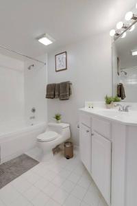 阿林顿Spectacular Condo 2/2 @Ballston With Gym的白色的浴室设有卫生间和水槽。