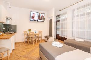 达洛科Apartamenty Plażowa 11的一间设有两张床、一间厨房和一张桌子的房间
