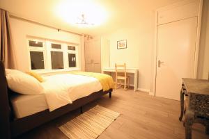 巴斯Bath City Skyline Spacious 3 Bed House for family的一间卧室配有一张床、一张书桌和一个窗户。