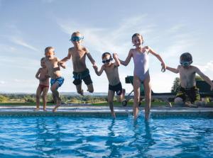 埃文河畔布拉德福伍利农庄奢华家庭旅馆的一群儿童跳入游泳池