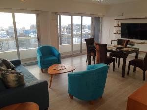 利马Encantador apartamento en Miraflores的客厅配有椅子、桌子和电视