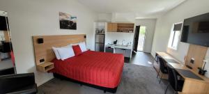 奥玛拉玛塞拉汽车旅馆及公寓的一间卧室配有红色的床和电视
