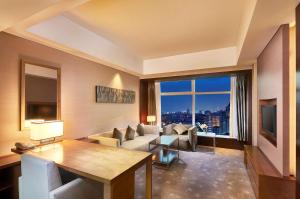 北京北京希尔顿逸林酒店的带沙发和大窗户的客厅