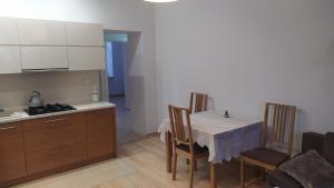 华沙Apartament Szczęśliwicka的一间带桌椅的厨房和一间带炉灶的厨房