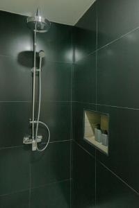芭堤雅市中心ONE LODGE Pattaya的一间设有黑色墙壁淋浴的浴室