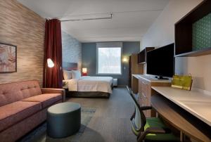 贝尔蒙特Home2 Suites By Hilton Charlotte Belmont, Nc的酒店客房,配有床和沙发