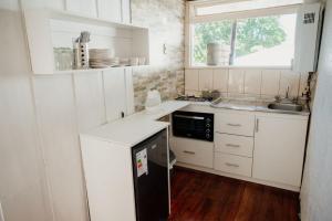 比亚里卡Leftraro Lodge Urbano的小厨房配有白色橱柜和水槽