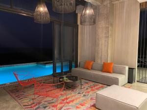 曼塔Eolia Sustainable Design Hotel的带沙发和游泳池的客厅
