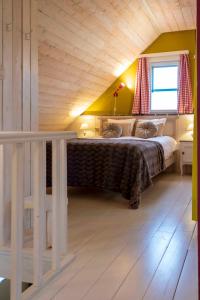 Zottegem米勒度假屋的一间卧室设有一张带木制天花板的大床