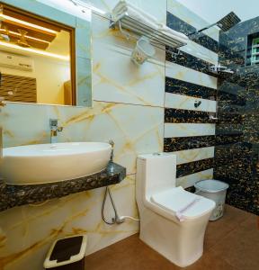科钦MARINA SUITES AIRPORT HOTEL的一间带水槽、卫生间和镜子的浴室