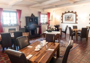 拉姆斯泰因-米森巴赫Hotel Rosenhof GmbH的餐厅设有木桌、椅子和壁炉