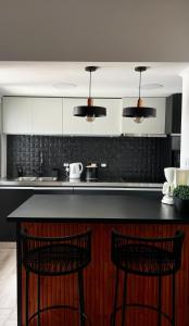拉斐拉Casa Atilio -Dpto Premium con entrada autónoma的厨房配有黑色柜台和2个吧台凳
