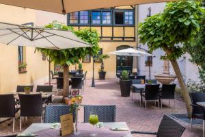 Weidazur altstadt的庭院内的餐厅,配有桌子和遮阳伞