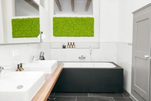拉芬斯堡HEIMATEL - Luxury Penthouse Loft的浴室配有两个盥洗盆和浴缸。