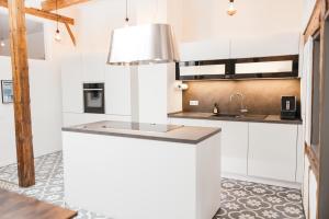 拉芬斯堡HEIMATEL - Luxury Penthouse Loft的厨房配有白色橱柜和水槽