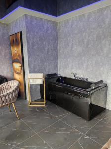波兹南石楠膳宿公寓的一间带黑色浴缸和椅子的浴室