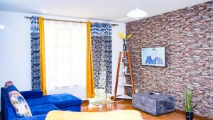 内罗毕Primal apartment at Embakasi, Nairobi, Kenya.的客厅设有蓝色的沙发和砖墙