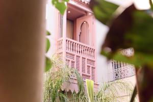 马拉喀什117号摩洛哥传统庭院住宅的一座粉红色的建筑,其一侧设有阳台