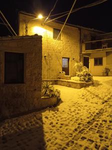 佩特拉利亚索普拉纳Casa Vacanze Borgo Gulini da Anna的一座房子,晚上有雪盖的院子