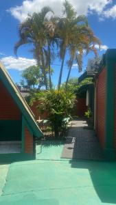 伊瓜苏港伊瓜苏花卉园公寓式酒店的一座两棵棕榈树和一条人行道的建筑