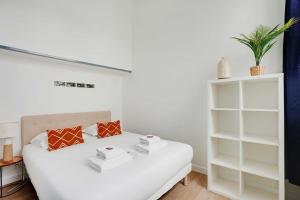 巴黎Charming Apartment- 2BR6P- Gare Montparnasse的卧室配有白色的床和白色架子