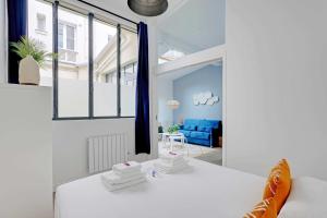 巴黎Charming Apartment- 2BR6P- Gare Montparnasse的客厅配有白色的沙发和窗户。