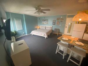 代托纳海滩Amazing Ocean View Studio Daytona Beach的一间卧室配有一张床、一张桌子和一张桌子。
