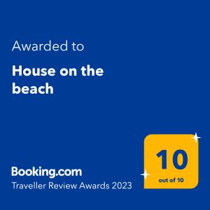 萨拉米斯House on the beach的海滩上的一个黄色标志,有房子