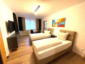 汉诺威Park-Residenz Isernhagen的酒店客房设有两张床和电视。
