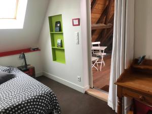 BourgheimB&B Le Lodge的一间卧室设有一张床,楼梯设有桌子