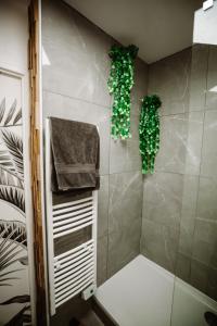奥贝维利埃L'Échappée Parisienne - Canal St-Denis的墙上设有绿色植物淋浴的浴室