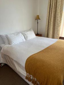里夫顿The Old Vicarage的一间卧室配有一张带白色床单的床和一扇窗户。