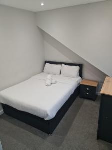 巴恩斯利APARTMENT in BARNSLEY CENTRAL的一张带白色床单和枕头的床