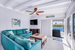 基克罗尼海滩Vitamin Sea的客厅配有蓝色的沙发和吊扇