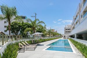 弗洛里亚诺波利斯Cannes Club Residence a 200m da praia, recém inaugurado的一座带躺椅的游泳池位于大楼旁