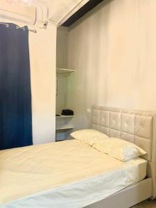 巴拿马城Centrico Apartamento Barrio de La Exposición的卧室配有白色的床和蓝色窗帘