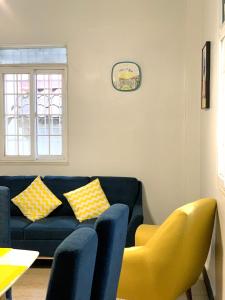 巴拿马城Centrico Apartamento Barrio de La Exposición的客厅配有蓝色的沙发和黄色的椅子