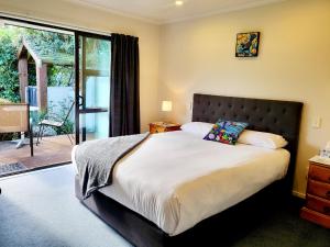 凯库拉Te Mahuru Retreat的一间带大床的卧室和一个阳台