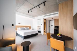 墨尔本Nesuto Docklands的酒店客房配有一张床铺和一张桌子。