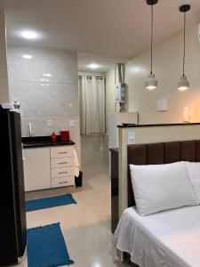 里约热内卢Loft 215 da Lapa, Rio de Janeiro的一间带白色床的卧室和一间厨房