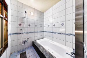 FushimiHotel Chronos -Adult Only的白色瓷砖浴室设有浴缸。
