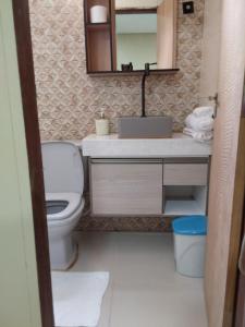 彼得罗利纳Chácara aconchego do Valle的一间带卫生间、水槽和镜子的浴室