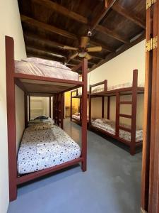 圣塔特蕾莎海滩Hostel Tuanis Surf Camp的一间房间,设有三张双层床