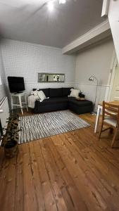 科科拉Apartment Wanha Kartano的客厅设有黑色沙发和木地板