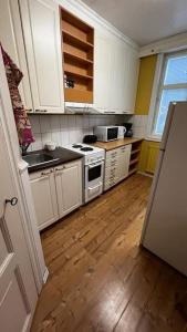 科科拉Apartment Wanha Kartano的厨房铺有木地板,配有白色橱柜。