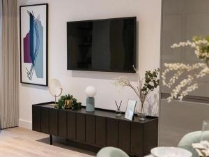 OltonLuxury Modern, One bedroom Flat的一间客厅,配有黑色橱柜和电视机