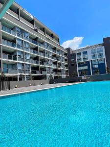纽卡斯尔AQUA 306 POOLSIDE Luxury Apartment , Honeysuckle, NEWCASTLE FREE Parking的大楼前的大型游泳池