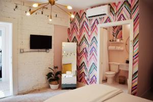 加尔维斯敦The Oleander Hotel Room Number 1的一间卧室设有色彩缤纷的墙壁和一间浴室。