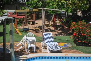 因巴塞Pousada Agua Marinha的一个带椅子的庭院和一个带滑梯的游乐场
